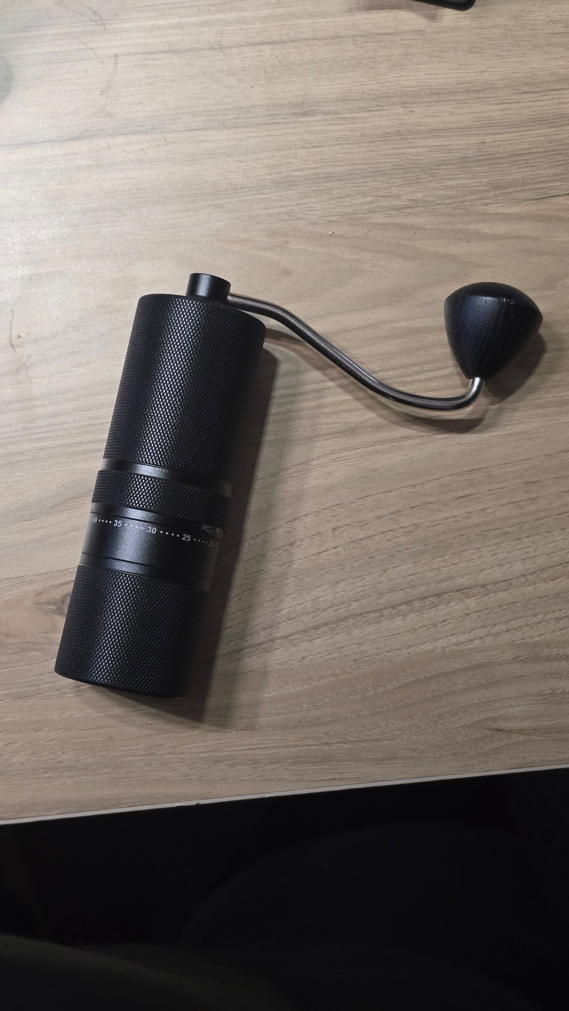 Molino de café manual negro con manivela y cuerpo con relieve knurling