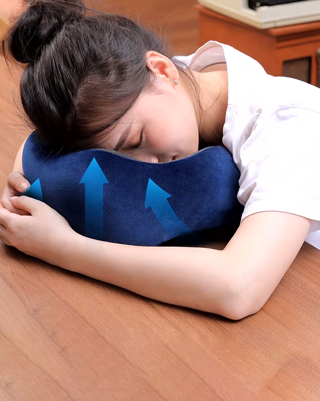 Almohada cervical azul con flechas de soporte, apoyada en el suelo